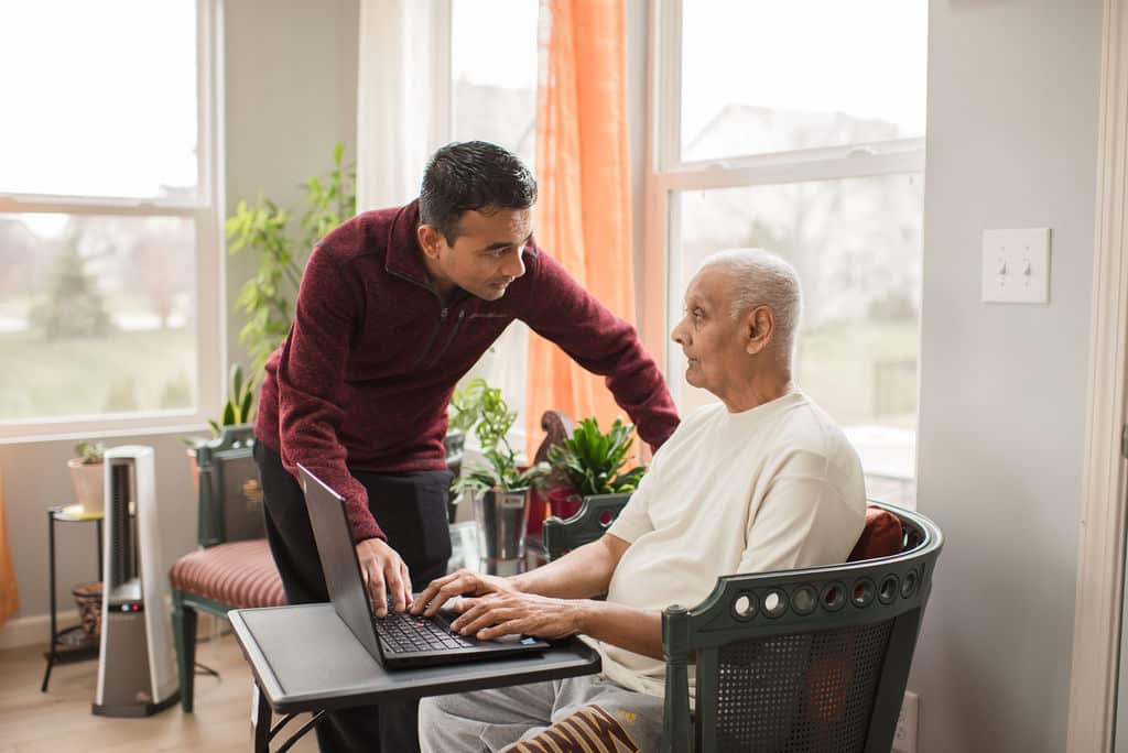 A son helps his dad log in to his patient portal.