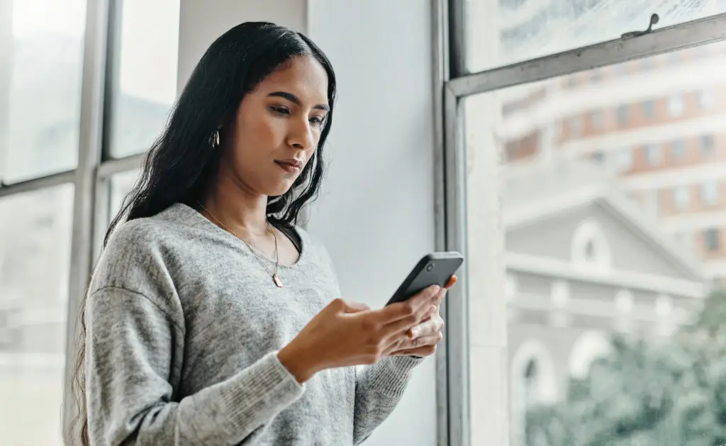 A young woman engages with Primary Record's Chat Assistant on her mobile phone where she keeps her family health record.